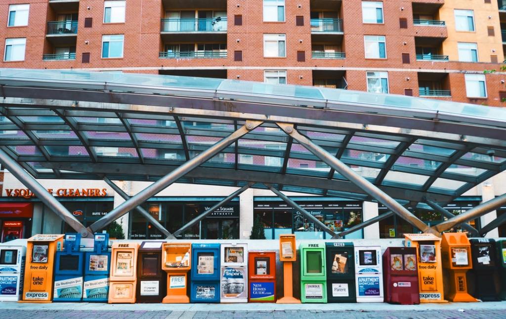 Image of newspaper boxes lined up outside of a metro station