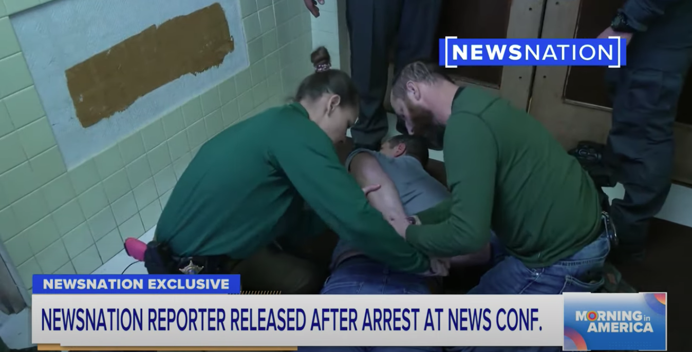 Screen grab of NewsNation broadcast showing the arrest of journalist Evan Lambert