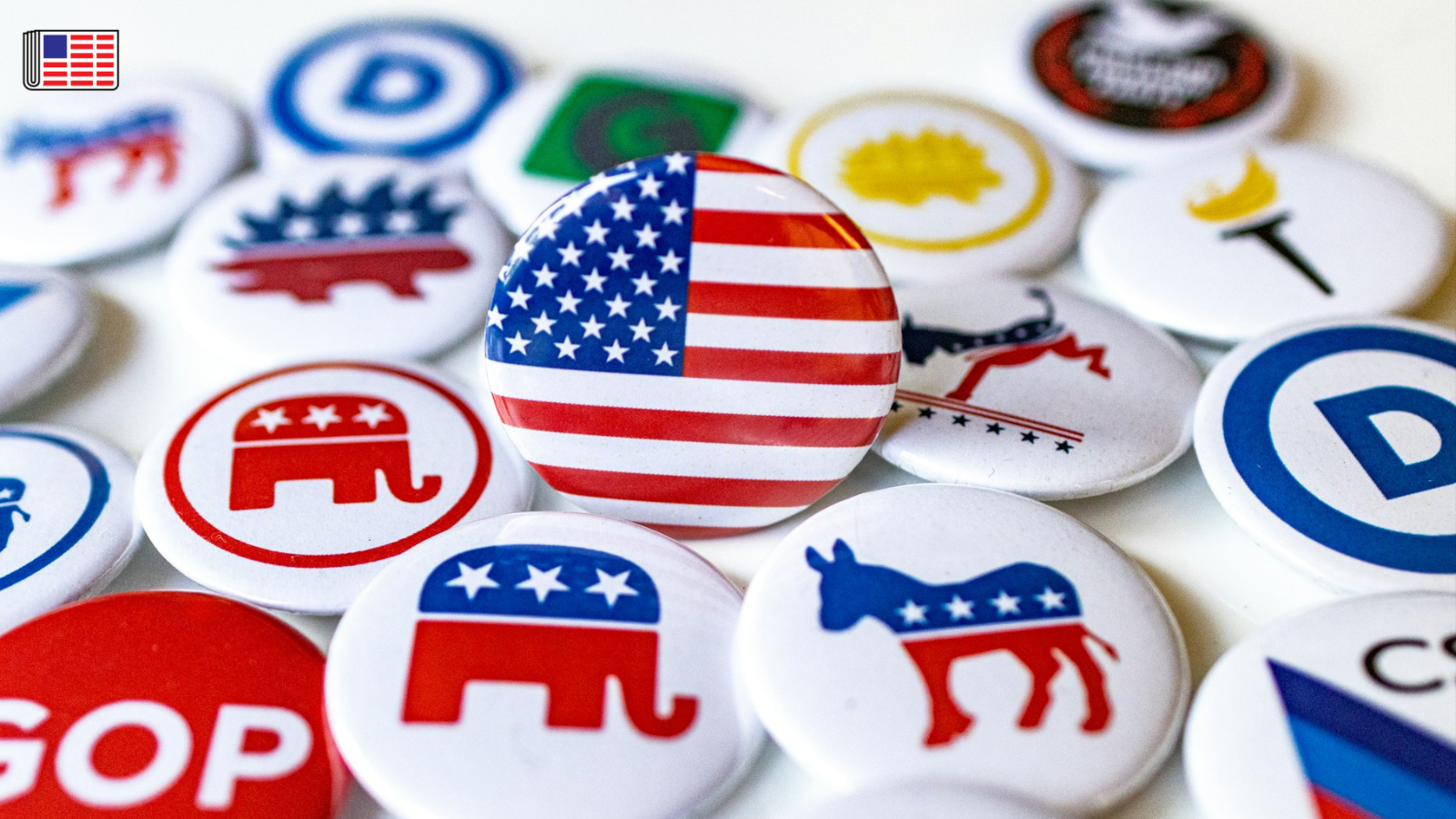 An assortment of political campaign pins with an American flag pin at the center. On the top left corner, the Reporters Committee flag logo is shown.
