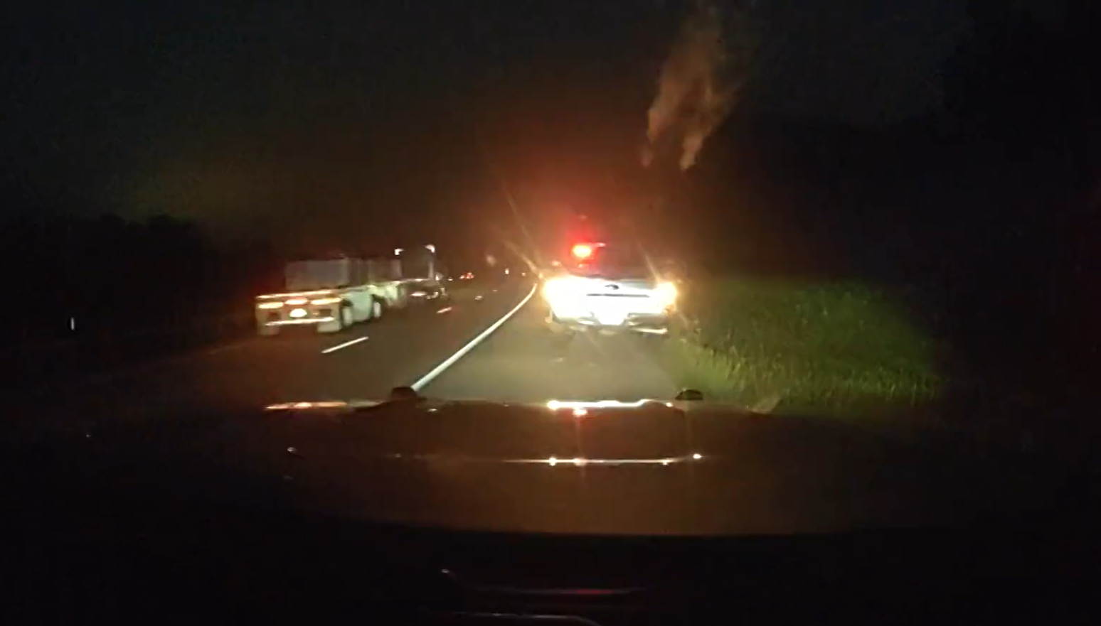 A screenshot from Pennsylvania State Police dashcam footage shows the back of a truck along the side of the road at night.