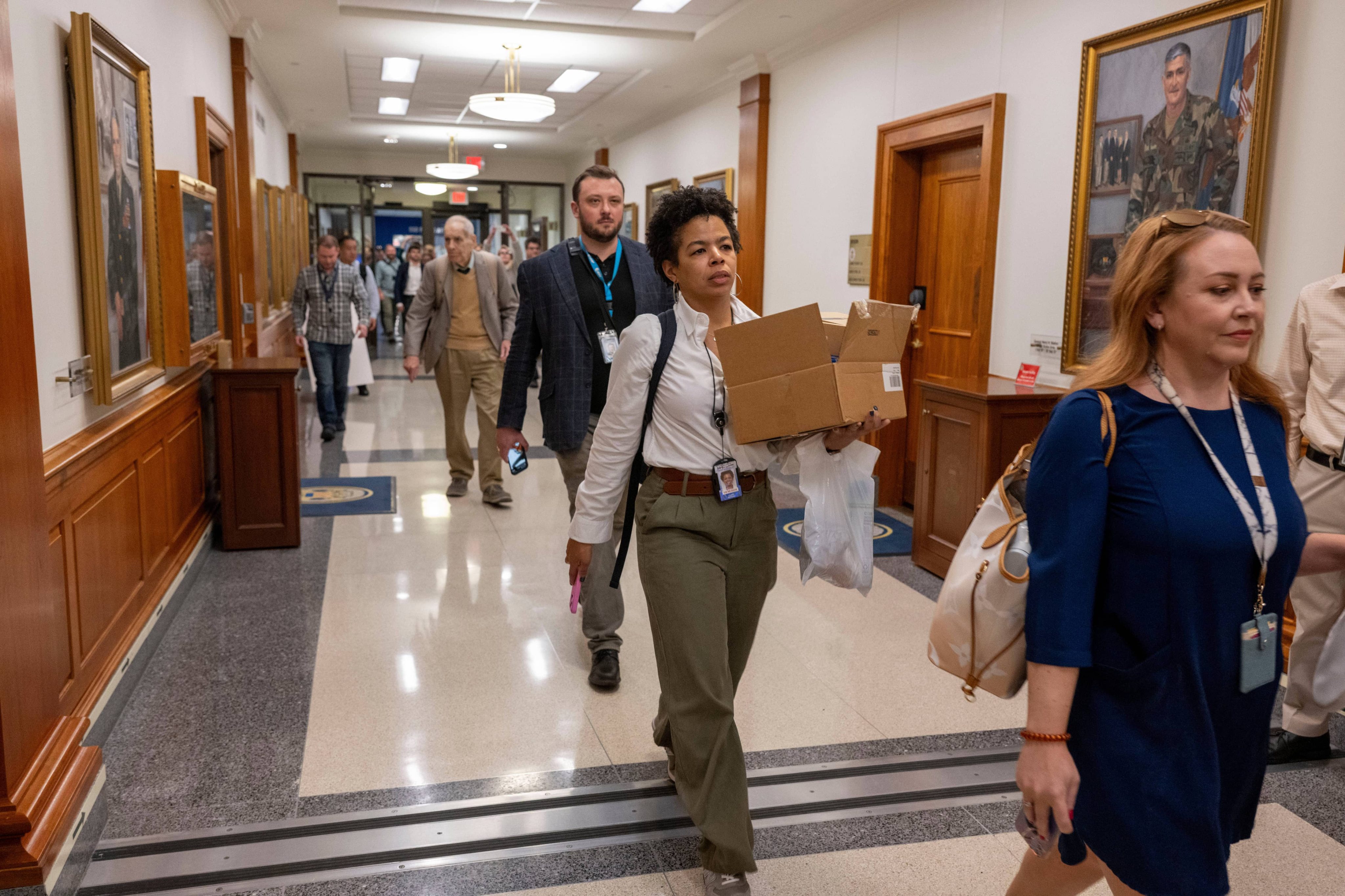 Members of the Pentagon press corp walk out of the Pentagon as a group after turning in their press credentials, Wednesday, Oct. 15, 2025 in Washington. (AP Photo/Kevin Wolf)