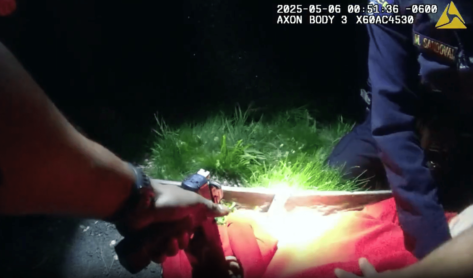 A screen grab from police bodycam footage shows an officer holding a gun to an unarmed man's head.