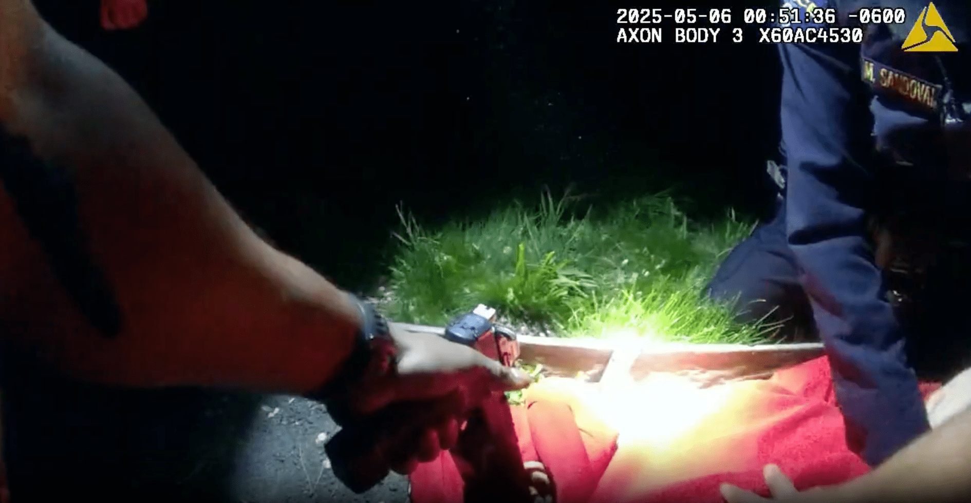 A screen grab from police bodycam footage shows an officer holding a gun to an unarmed man's head.